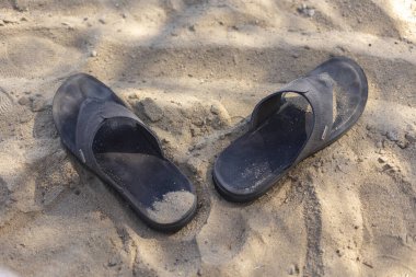 Marsa Alam, Mısır 'ın kumlu sahilinde terk edilmiş rahat ayakkabılar. Sıcak güneşin ve rahatlamanın tadını çıkarıyorlar.