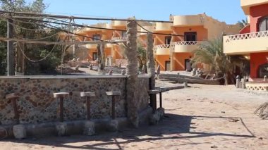 Eskimiş taş plaj barı, Marsa Alam, Mısır 'daki Kızıl Deniz kıyısındaki ıssız bir tatil köyünde boş duruyor. Sessiz yalnızlık ve mimari bozulmayı ortaya çıkarıyor.