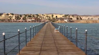Marsa Alam, Mısır 'da bir tatil köyüne doğru uzanan ahşap banklı iskele rahatlatıcı ve keyif verici.