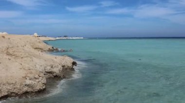 Sakin turkuaz su, Marsa alam kıyılarına yavaşça vurarak sakin bir sahil sahnesi oluşturur.