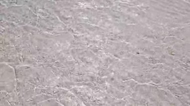 Şeffaf su, Marsa Alam 'ın dingin kızıl deniz kıyı manzarasındaki berrak kristal derinlikleri ortaya çıkararak el değmemiş beyaz deniz tabanında yavaşça akıyor.