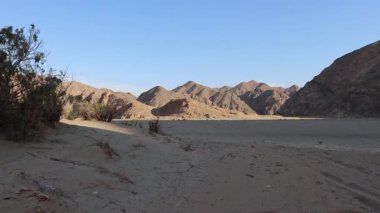 Görkemli dağlar Marsa Alam, Mısır 'daki kumlu alanla buluşur ve çöl manzarasının ham güzelliğini gösterir.