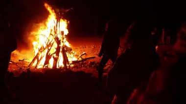 Marsa alam çöl turistleri gece parlayan alevlere ve karanlık manzaraya karşı sıcak siluetler oluşturarak yanan ahşap kamp ateşinin etrafında toplanıyorlar.