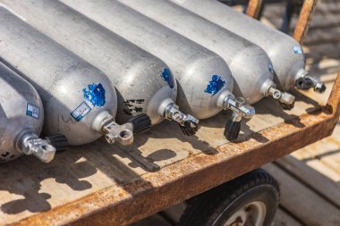 Marsa alam, Mısır 9 Şubat 2025: Paslı bir metal sepetin üzerinde bulunan dalış tankları, Marsa alam, Mısır 'daki canlı mercan resiflerini araştıran dalgıçlara hazırdır.