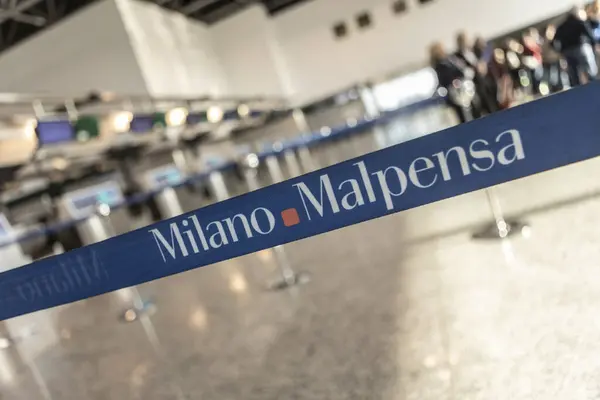 Milan, İtalya 13 Şubat 2025: Terminal içindeki Milano Malpensa havaalanı logo yolcularıyla mavi kuyruk ayırıcıları