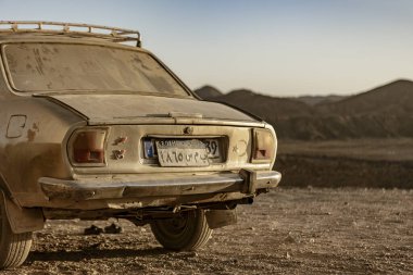 Marsa alam, Mısır 9 Şubat 2025: toz kaplı klasik araba engin Marsa alam çölünde terk edilmiş duruyor, engebeli bir araziye karşı izolasyon ve zamansızlık hissi uyandırıyor.