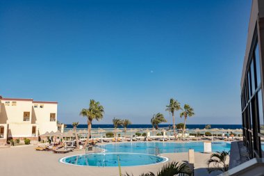 Marsa alam, Mısır 9 Şubat 2025: Marsa alam, Mısır 'da palmiye ağaçları ve okyanus zeminli sakin bir tatil köyü açık mavi gökyüzü altında sakin bir kaçış teklif ediyor.