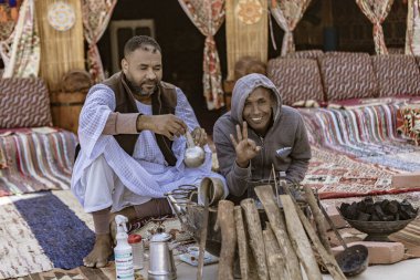 Marsa alam, Mısır 9 Şubat 2025: Marsa alam, Mısır 'da geleneksel çay, sergilenen kültürel miras ve konukseverlik hazırlayan, rahat, renkli bir ortamda iki adam,