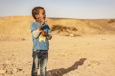 Marsa alam, Mısır 9 Şubat 2025: Marsa alam çölünde yemek yiyen genç bir çocuğun portresi, yoksulluk ve açlığın acı gerçeklerini gösteriyor.