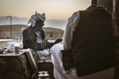 Marsa alam, Mısır 9 Şubat 2025: bedevi erkekler çölde güzel bir gün batımında Marsa alam, Mısır 'da geleneksel kahve hazırlayıp içiyorlar.