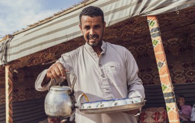 Marsa alam, Mısır 9 Şubat 2025: Bedevî adam Marsa Alam, Mısır 'da süslü bir çadırda geleneksel çay dolduruyor.