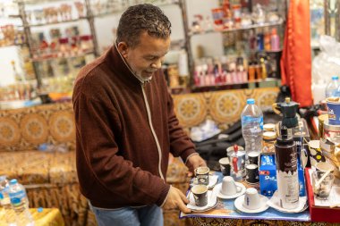 Marsa alam, Mısır 9 Şubat 2025: Marsa alam 'da geleneksel bir Mısır dükkanında müşterilere servis yapmak için tepside kahve fincanları düzenleyen dükkan sahibi