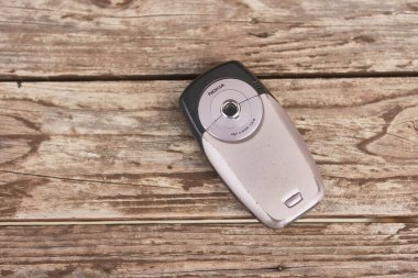 Milan, İtalya 13 Mart 2025: Eski nokia 6600 cep telefonu yıpranmış ahşap bir yüzey üzerinde dinleniyor, antika tasarımını sergiliyor ve 2000 'lerin başında nostalji uyandırıyor.