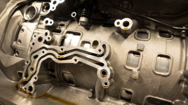 Bir motor bloğunun kanallarından akan petrol otomotiv teknolojisinin karmaşık tasarımı ve hassas mühendisliğini vurguluyor.