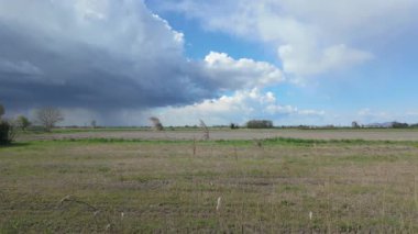 Fimon Gölü 'nün yakınındaki sakin bir arazide kara bulutlar toplanıyor. Bu da İtalyan kırsalında yaklaşan fırtınayı işaret ediyor.