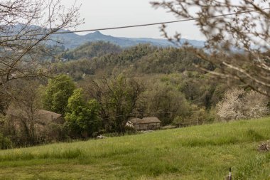 İtalya 'nın kırsal kesimindeki yeşil tepelerin arasına yerleşmiş bir çiftlik evinin manzarası kırsal kesimin güzelliğini gözler önüne seriyor.