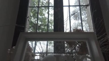 Roma, İtalya, 4 Mayıs 2025: çay saati yazılı beyaz dekoratif çerçeve, kurutulmuş çiçekler ve cam kenarındaki bir masaya bir çay kutusu çeşitli düzenlenir