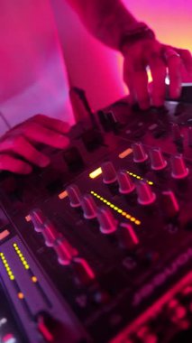 Roma, İtalya 4 Mayıs 2025: canlı bir gece kulübünde DJ 'in elleri düğmeleri ve fadleri manipüle ediyor.