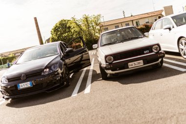 Roma, İtalya, 4 Mayıs 2025: klasik bir beyaz Volkswagen golf gti park yerinde modern siyah bir Volkswagen golf gti yanında park, bu ikonik arabanın evrimini gösteriyor