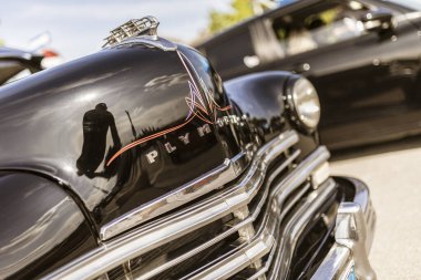 Roma, İtalya 4 Mayıs 2025: Plymouth kaput süslemesinin yakın görüntüsü, fotoğrafçıyı yansıtıyor, klasik bir araba fuarında.