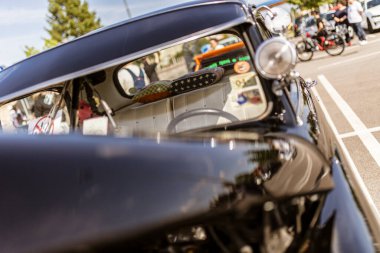 Roma, İtalya 4 Mayıs 2025: Bir araba fuarında klasik bir arabanın iç mekanına yakın çekim, ön camdaki eski yastıkları ve çıkartmaları renklendiriyor.