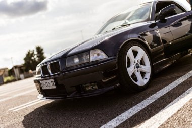 Roma, İtalya 4 Mayıs 2025: spor tasarımı ve klasik cazibesini vurgulayarak, üstü açık beyaz tekerlekli bir BMW E36 'nın düşük açılı görüntüsü