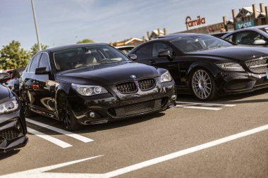 Roma, İtalya 4 Mayıs 2025: güneşli bir günde güneşli bir otoparkta Mercedes 'in yanına park etmiş parlak siyah renkli BMW