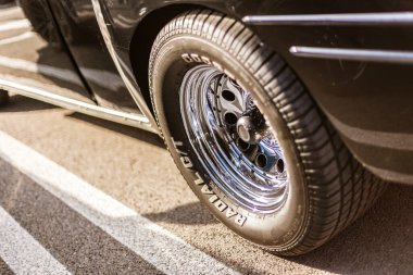 Roma, İtalya, 4 Mayıs 2025: klasik bir araba lastiğinde parlayan cilalı krom tekerlek, asfalta park edilmiş, klasik otomotiv stili sergileniyor