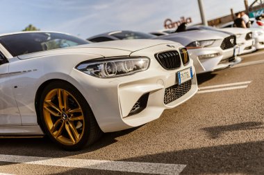 Roma, İtalya 4 Mayıs 2025: gösterişli beyaz BMW arabası, diğer araçların yanına park edilmiş altın tekerlekler.