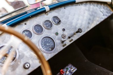 Roma, İtalya, 4 Mayıs 2025: klasik bir spor araba gösterge panelinin yakın görüntüsü, analog göstergeler ve anahtarlar, aracın klasik cazibesini vurguluyor