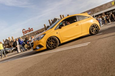 Roma, İtalya 4 Mayıs 2025: ayarlı sarı bir Opel Corsa Gsi 'nin alçak açılı görüntüsü park halindeki bir otoparkta izleyiciler tarafından hayran bırakıldı.