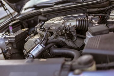 Roma, İtalya 4 Mayıs 2025: Hortumlardan, borulardan ve elektrik kablolarından oluşan karmaşık ağı ortaya çıkaran bir araba motoru kompartımanının yakın çekimi, modern bir aracın güç kaynağının karmaşık çalışmalarını vurguluyor