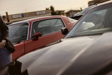 Roma, İtalya 4 Mayıs 2025: klasik arabalar park yerinde arka arkaya park edilmiş, batan güneşin sıcak ışığını yansıtıyorlar.