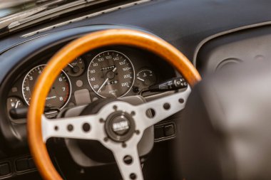 Roma, İtalya, 4 Mayıs 2025: bir spor arabadaki hız, devir ve yakıt seviyesini gösteren tahta direksiyon ve torpido gözüne yakın çekim