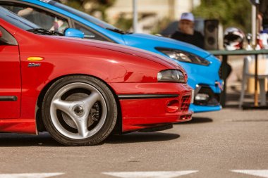 Roma, İtalya 4 Mayıs 2025: Akortlu kırmızı bir fiat bravo Hgt 20 v 'nin önünde mavi bir Ford Focus Rs' a yakın park edilmiş jantları var.