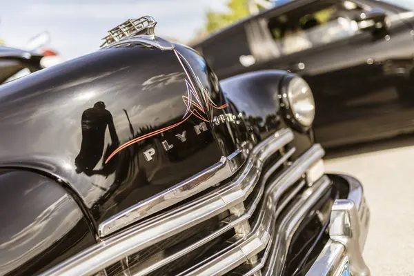 Roma, İtalya 4 Mayıs 2025: Plymouth kaput süslemesinin yakın görüntüsü, fotoğrafçıyı yansıtıyor, klasik bir araba fuarında.