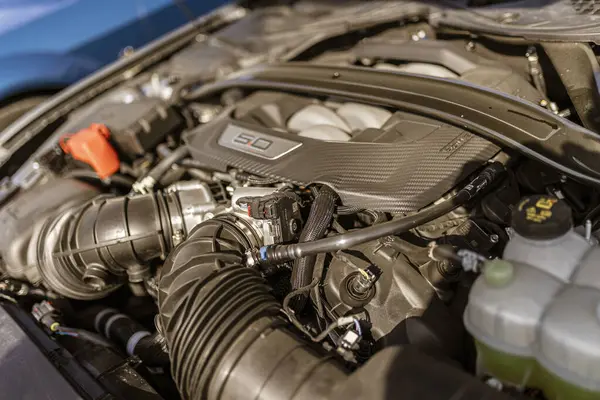Roma, İtalya 4 Mayıs 2025: Ford Mustang 'in tanımlayıcı özelliği olan güçlü 5.0 Coyote V8 motoruna yakın çekim, karmaşık bileşenleri ve ham gücü vurguluyor.