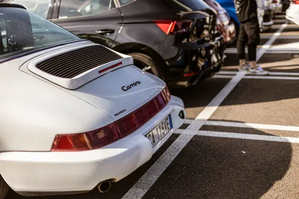 Roma, İtalya 4 Mayıs 2025: Beyaz Porsche Carrera Cabriolet 'in arka görüntüsü park yerinde park edilmiş, klasik tasarımı ve zarafeti sergileniyor.