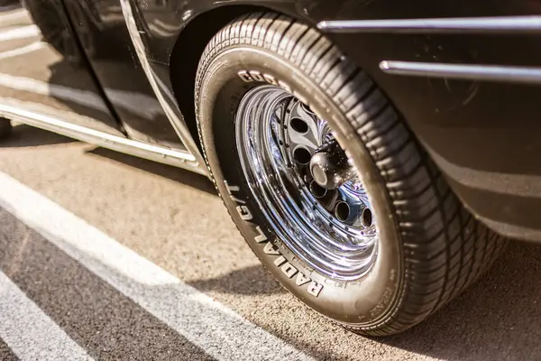 Roma, İtalya, 4 Mayıs 2025: klasik bir araba lastiğinde parlayan cilalı krom tekerlek, asfalta park edilmiş, klasik otomotiv stili sergileniyor