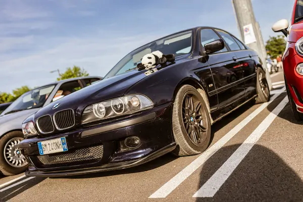Roma, 4 Mayıs 2025: Otoparka park edilmiş BMW E39 Sedan, kaputun üzerinde panda pelüş oyuncağı var.
