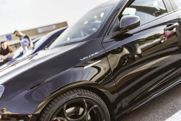 Roma, İtalya 4 Mayıs 2025: Parlak siyah alfa romeo giulietta hızına yakın çekim çevresini yansıtıyor, parlak tasarımı ve spor estetiği sergiliyor