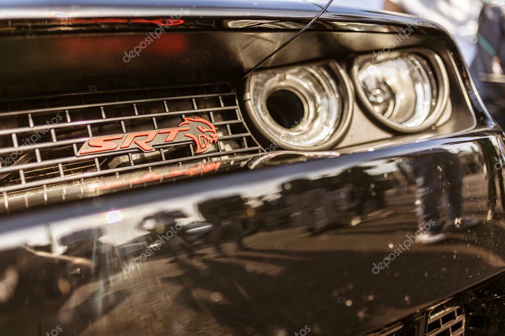 Rome, italy 4 may 2025: shiny black dodge challenger srt hellcat front grill and headlights reflecting surrounding environment