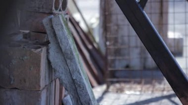 Metal korkuluklar yavaş yavaş bulanık tuğla ve beton blok arka planına karşı keskin bir odak noktasına geliyor, endüstriyel mimari ayrıntıları seçici alan derinliğiyle vurguluyor