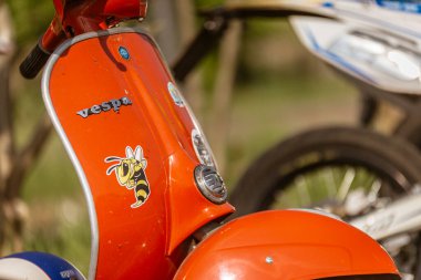 Roma, İtalya 4 Mayıs 2025: Açık havada park edilmiş karikatür arı çıkartmalı turuncu vespa scooter klasik İtalyan tasarımı ve kişiselleştirilmiş detaylar sergiliyor.