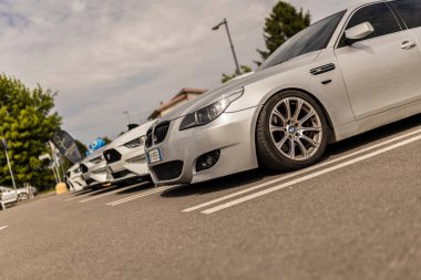 Roma, İtalya 4 Mayıs 2025: Bir otoparkta park edilmiş gümüş bir BMW 'nin düşük açılı görüntüsü, spor tasarımı ve alaşım tekerleklerini sergiliyor, diğer arabalar arka planda hafifçe görünür.