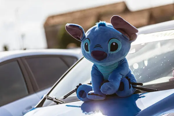 Roma, İtalya 4 Mayıs 2025: Disney 'in lilo ve dikişinden dikişe benzeyen mavi peluş oyuncak bir arabanın kaputunda duruyor.