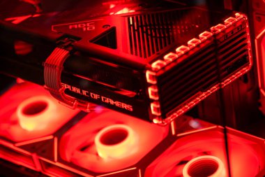 Roma, İtalya, 10 Mayıs 2025: kırmızı ışıklı yüksek performanslı bir grafik kartına yakın çekim, bir oyun bilgisayarına yüklenmiş, gelişmiş soğutma sistemini ve güçlü kapasitesini gösteriyor