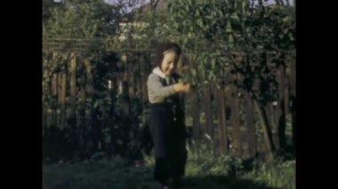 Londra, Birleşik Krallık Mayıs 1963, tapılası çocuk gülümsedi ve 1960 'larda Birleşik Krallık' ta bir bahçede çiçek tuttu.