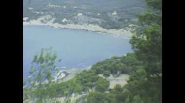 Londra, Birleşik Krallık Mayıs 1973, tarihi Akdeniz kıyı sahnesi yemyeşil tepeler, kayalık arazi, uzak sahil kasabası ve parıldayan deniz manzarası arasında kurulmuş tarihi gözlem kulesini gözler önüne seriyor.