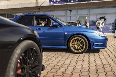 Milan, İtalya. 4 Haziran 2025. Akortlu subaru impreza wrx sti 'yi sunan hevesli sürücüler bir araba ayarlama etkinliğinde altın jantlarla karşılaşıyorlar.